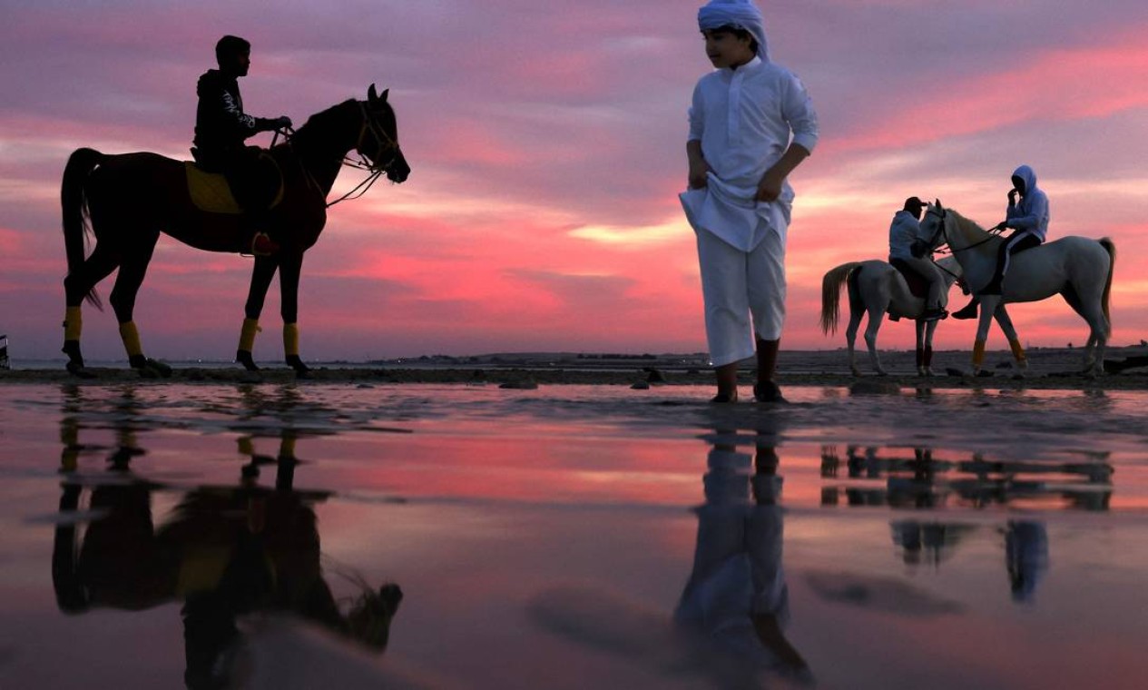 Emirados montam seus cavalos durante o pôr do sol em Abu Dhabi Foto: KARIM SAHIB / AFP