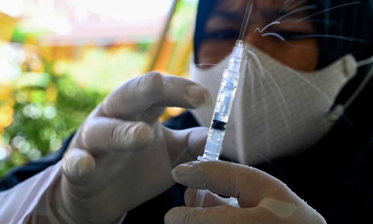 Profissional de saúde prepara uma seringa com a vacina Sinovac contra o coronavírus em uma escola primária islâmica em Banda Aceh, Indonésia Foto: CHAIDEER MAHYUDDIN / AFP