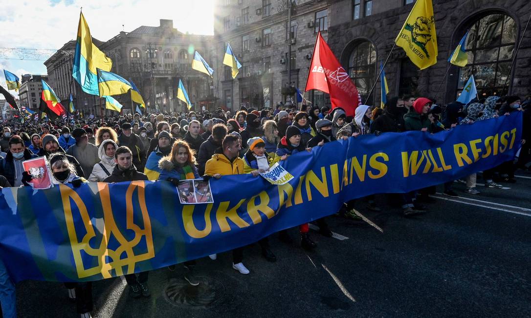 Manifestantes em Kiev com uma faixa escrita "Ucranianos vão resistir", em meio a temores de uma invasão russa Foto: SERGEI SUPINSKY / AFP