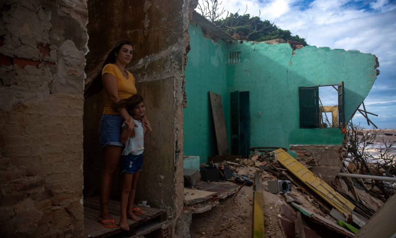 Raissa Boamorte e sua filha no que fazia parte de sua casa. Na localidade, só continuam de pé 108 casas com 302 habitantes Foto: MAURO PIMENTEL / AFP