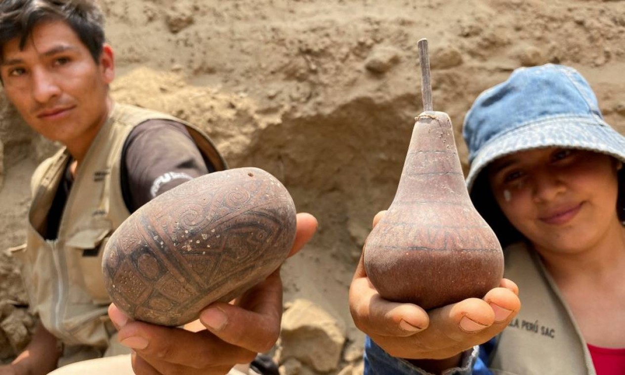 Arqueólogos peruanos mostram peças de cerâmica encontradas junto com as múmias no Peru Foto: STRINGER / REUTERS