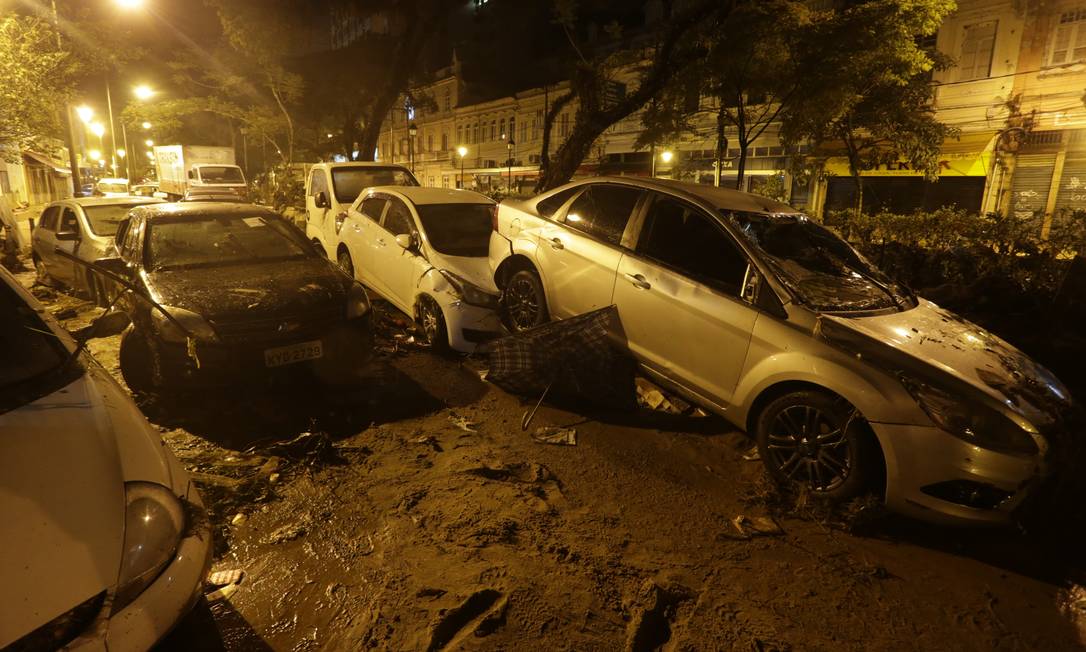 Diversos carros foram arrastados pela força da enxurrada. Volume de chuva ultrapassou o esparado para um mês inteiro Foto: Domingos Peixoto / Agência O Globo