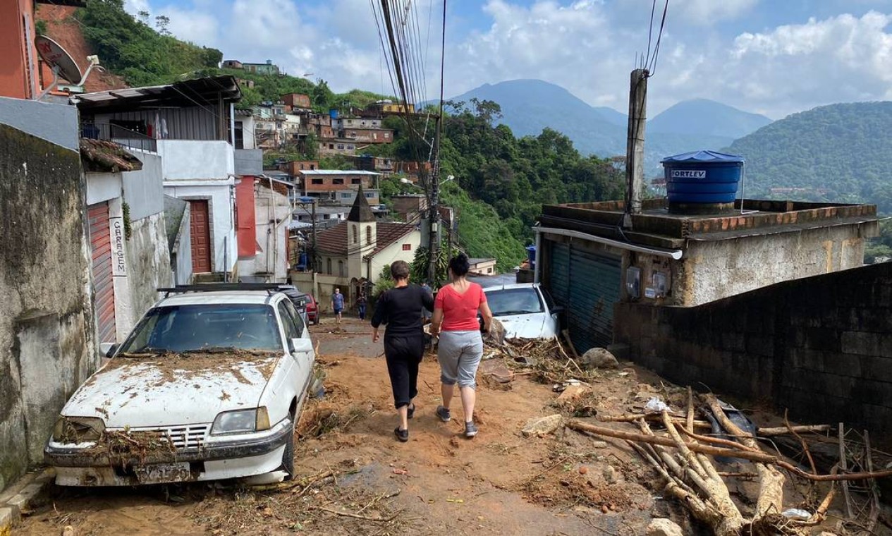 Moradores caminham pela Rua Nova, no bairro 24 de Maio. A paisagem foi transformada pelo barro Foto: Márcia Foletto / Agência O Globo