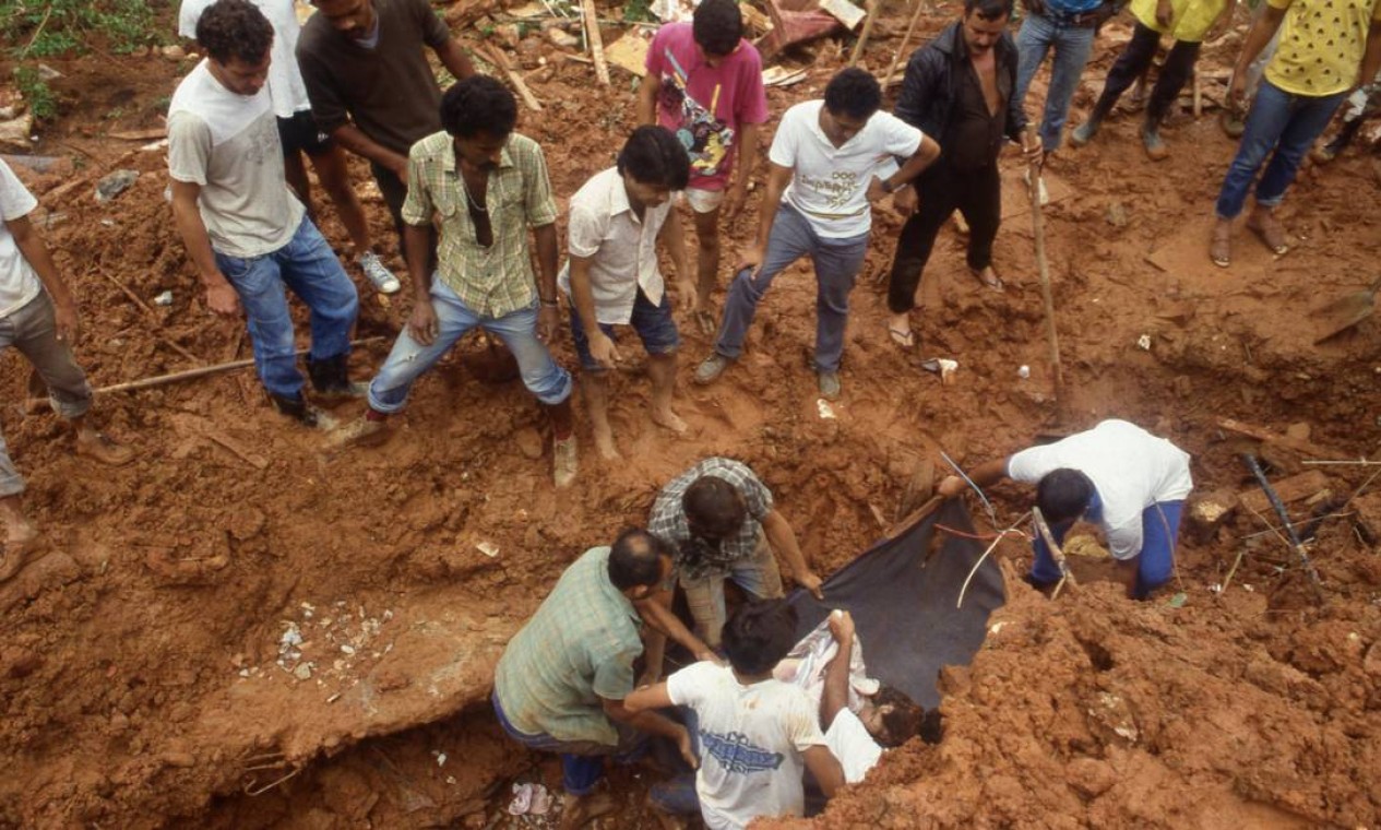 Populares resgatam corpo de Marly Machado de Souza, vítima da tragédia provocada pelas chuvas Foto: Otávio Magalhães / Agência O Globo - 07/02/1988