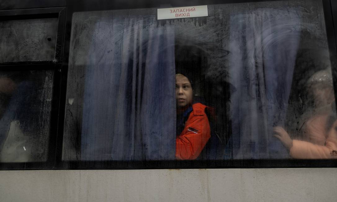 Criança olha pela janela de um ônibus enquanto viaja para fora de Kiev Foto: CARLOS BARRIA / REUTERS