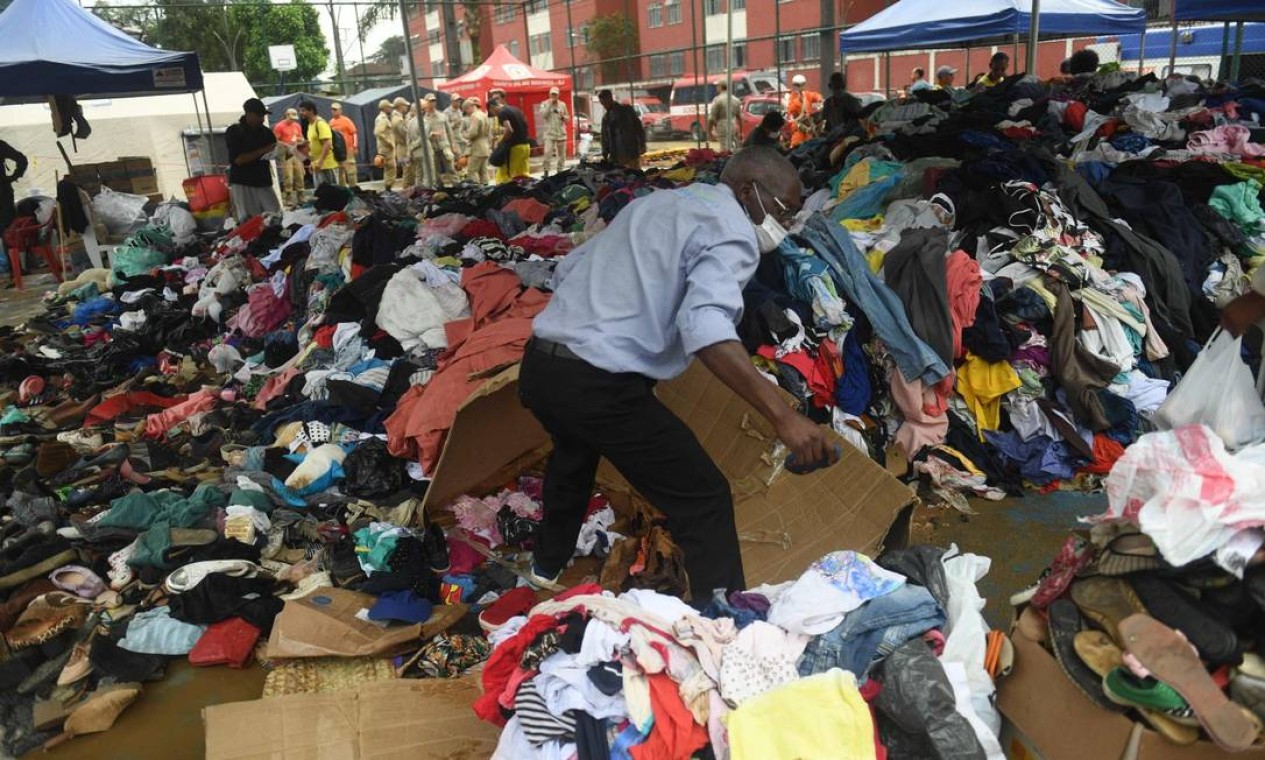 Vítima de deslizamento de terra examina roupas doadas aos desabrigados Foto: Mauro Pimentel / AFP