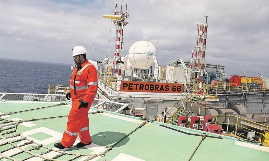 Foto: Trabalhador caminha em plataforma da Petrobras na Bacia de Santos, uma das áreas de produção do pré-sal: alta do preço internacional do petróleo está turbinando lucros da estatal / Pilar Olivares/Reuters/5-9-2018