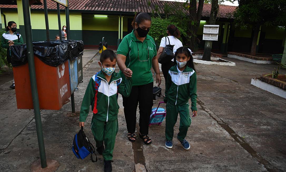 Crianças chegam a uma escola pública no primeiro dia de aulas presenciais após dois anos e meio de ensino remoto devido à pandemia de Covid-19, em Assunção, no Paraguai Foto: NORBERTO DUARTE / AFP