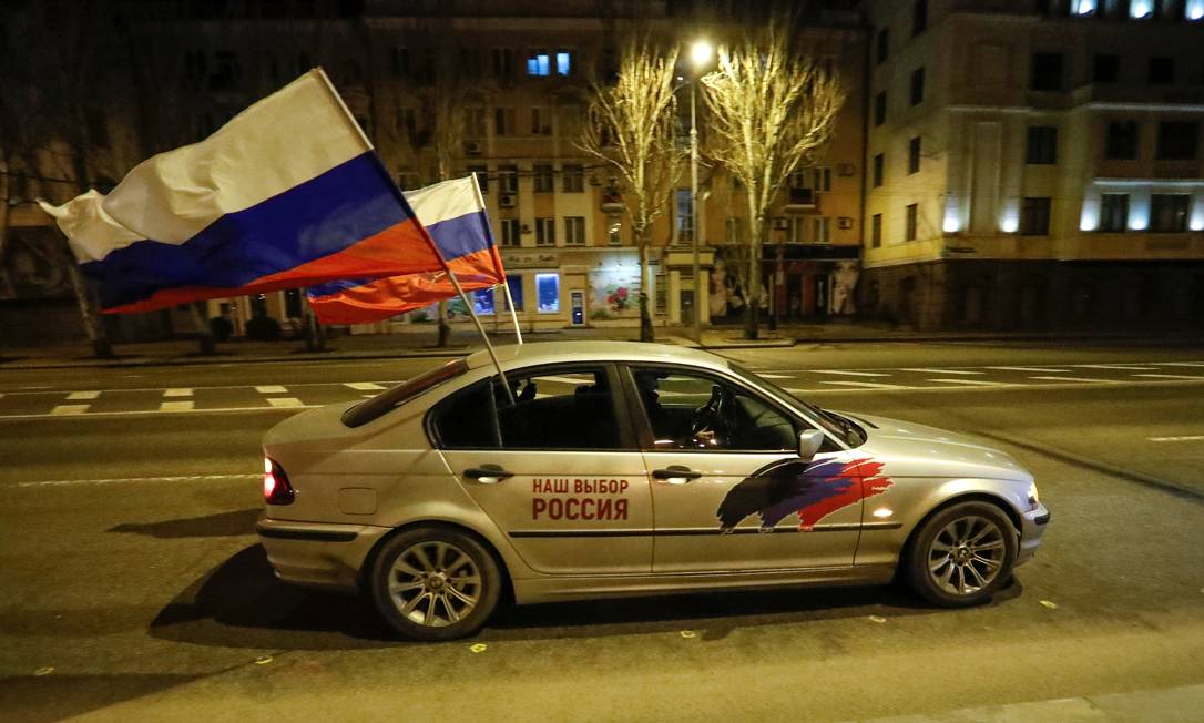 Carro com bandeiras da Rússia trafega pelas ruas de Donetsk, logo depois do anúncio de que as repúblicas separatistas no Leste ucraniano seriam reconhecidas por Moscou Foto: ALEXANDER ERMOCHENKO / REUTERS