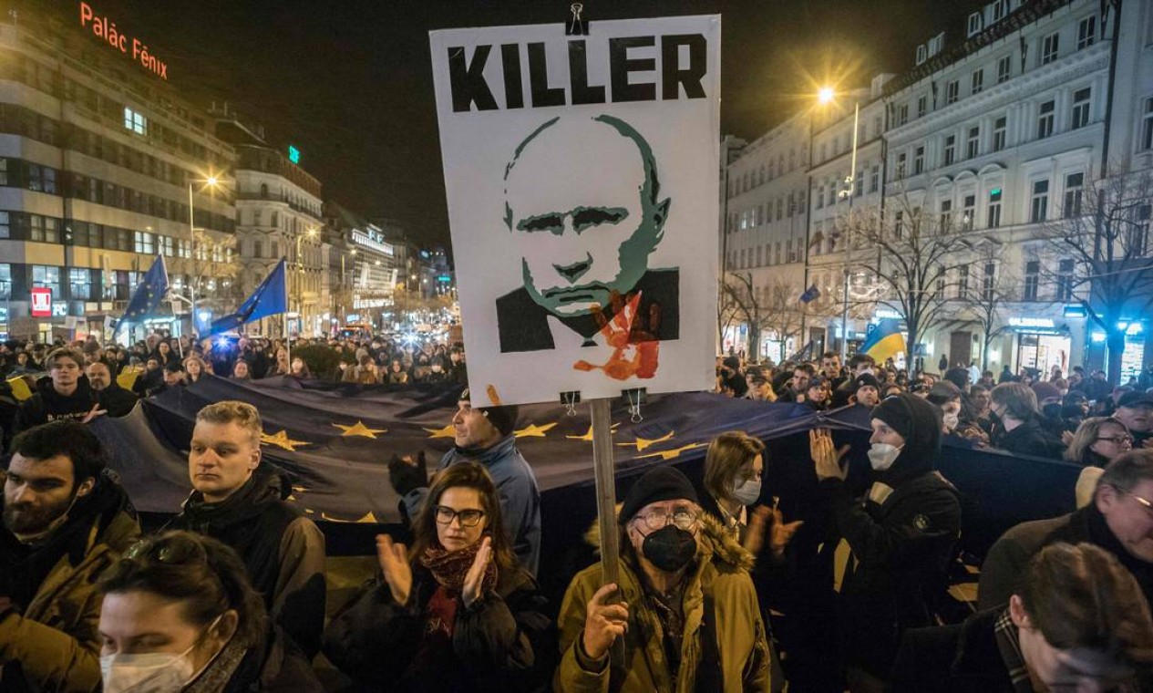 Manifestante pró-Ucrânia exibe um cartaz que chama o presidente russo, Vladmir Putin, de assassino, na praça Venceslas em Praga, República Tcheca, após o reconhecimento da Rússia aos separatistas do leste ucraniano Foto: MICHAL CIZEK / AFP