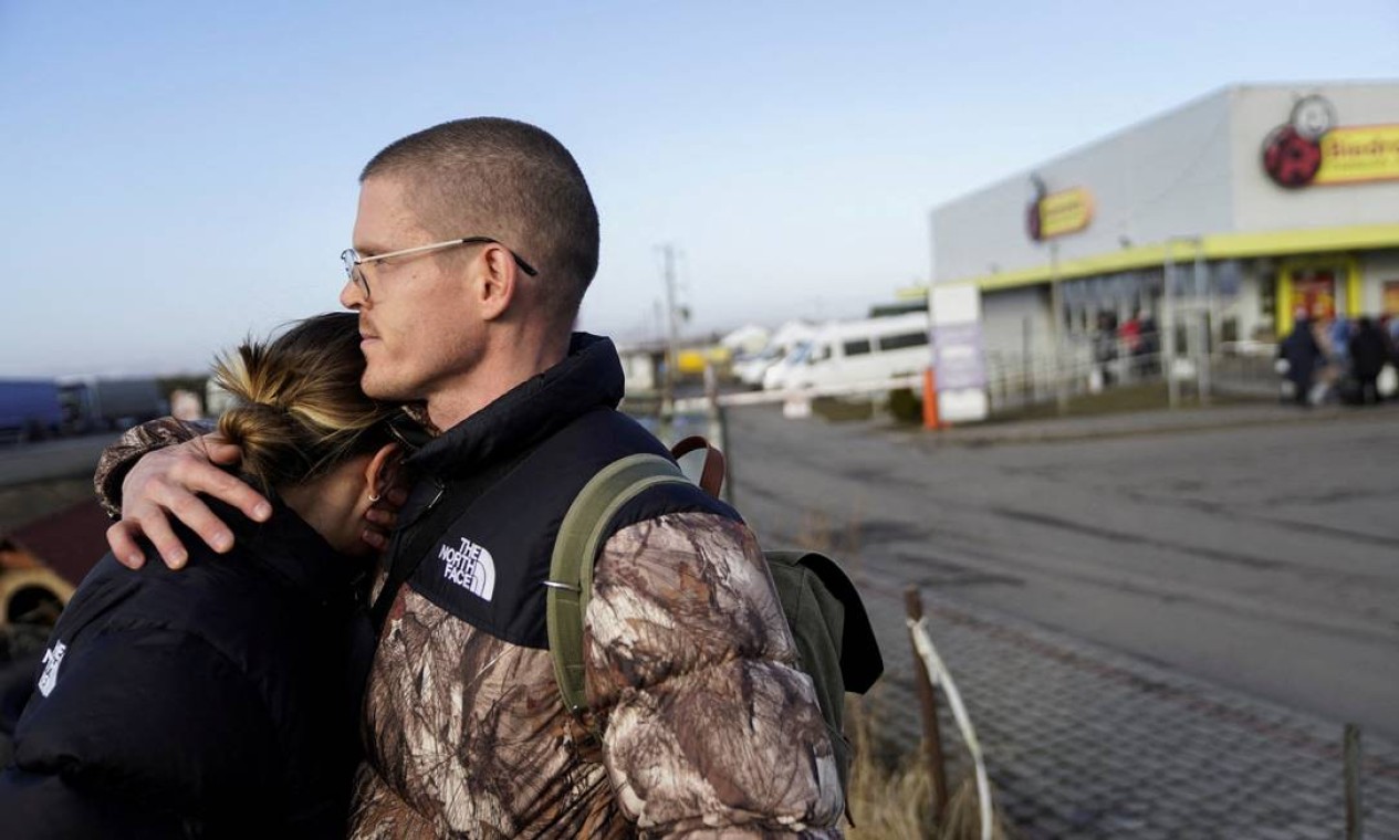 Casal americano se abraça após cruzar a fronteira e fugir da violência na Ucrânia, em Medyka, Polônia Foto: BRYAN WOOLSTON / REUTERS