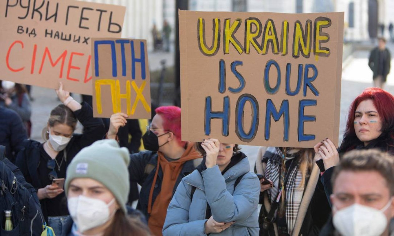 Manifestantes seguram um cartaz dizendo "A Ucrânia é nossa casa" em frente ao Ministério das Relações Exteriores da Áustria durante protesto contra a invasão da Ucrânia pela Rússia, em Viena, Áustria Foto: ALEX HALADA / AFP