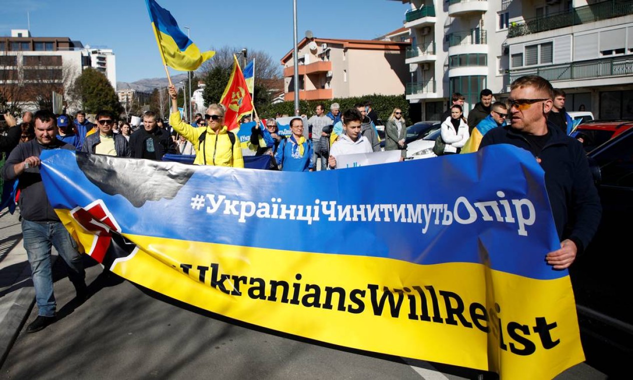 Ucranianos que vivem em Montenegro protestam contra operação a Rússia na Ucrânia, perto do consulado russo em Podgorica Foto: STEVO VASILJEVIC / REUTERS
