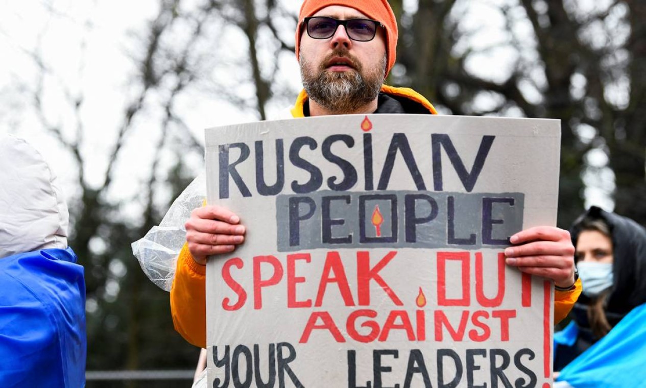 Manifestante exibe um cartaz durante um protesto contra o ataque da Rússia à Ucrânia, do lado de fora do parlamento holandês em Haia, Holanda Foto: PIROSCHKA VAN DE WOUW / REUTERS