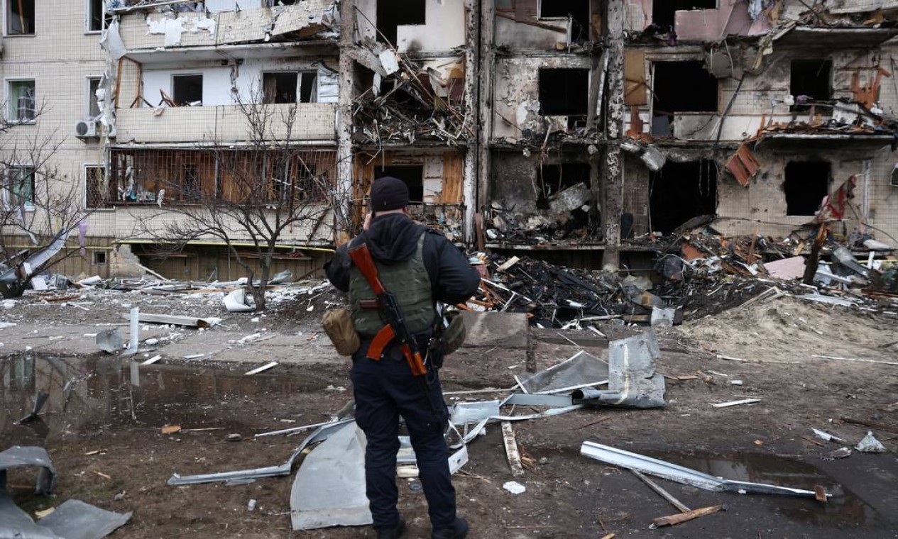 Pessoa fica em frente a um prédio residencial danificado, depois que a Rússia lançou uma operação militar maciça contra a Ucrânia, em Kiev, Ucrânia Foto: UMIT BEKTAS / REUTERS