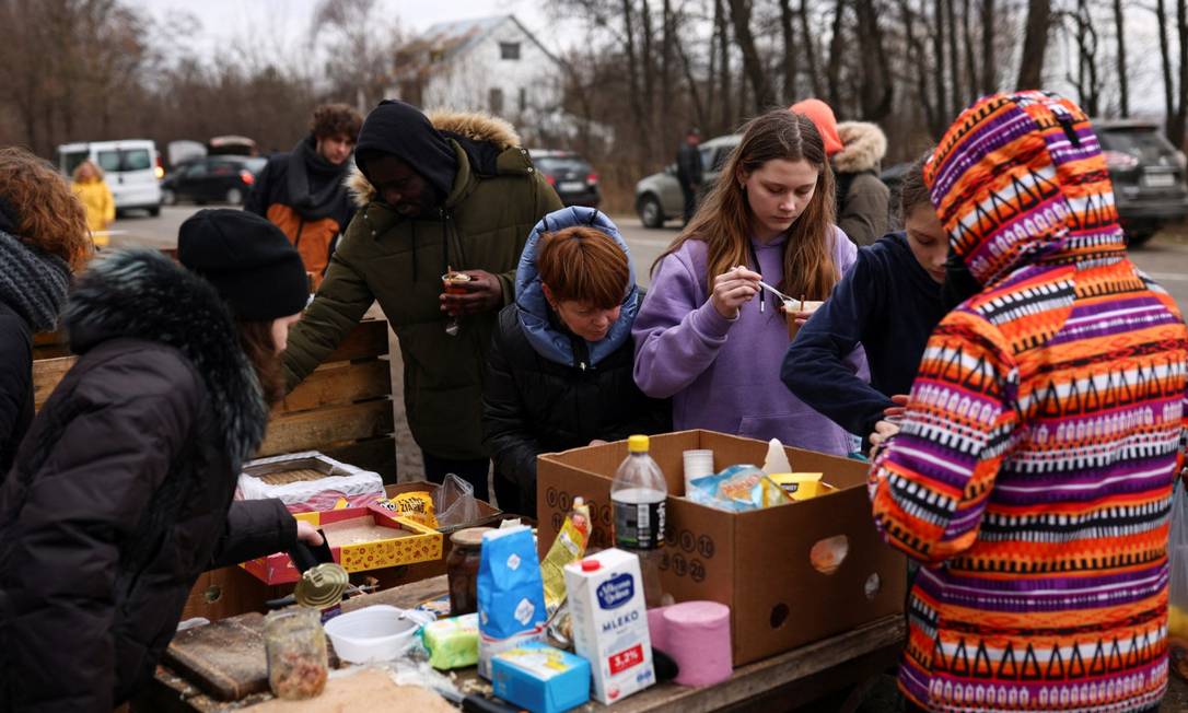 People fleeing Russia's military operation against Ukraine receive food at a food station set up by volunteers, near the Shehyni border crossing to Poland, outside Mostyska, Ukraine, February 27, 2022. REUTERS/Thomas Peter Foto: THOMAS PETER / REUTERS