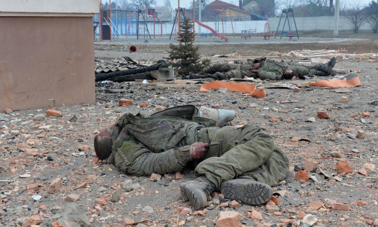 Corpos de soldados russos estavam do lado de fora de uma escola destruída em Kharkiv Foto: SERGEY BOBOK / AFP