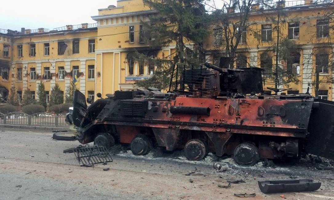 Veículo blindado ucraniano destruído é visto em frente a uma escola após bombardeio em Kharkiv Foto: VITALIY GNIDYI / REUTERS