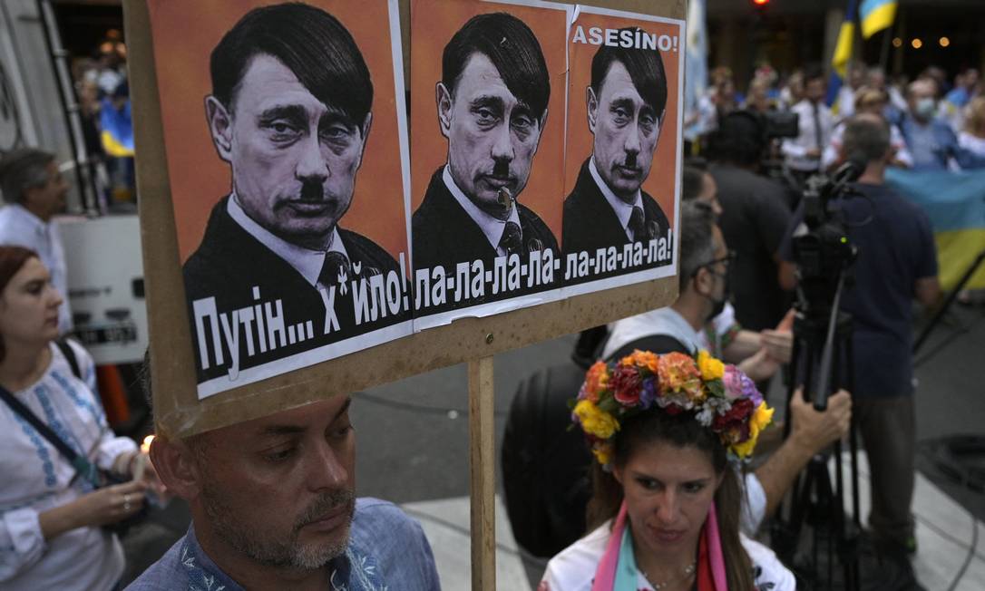 Cartaz compara o presidente Vladimir Putin a Adolf Hitler durante protesto em frente à embaixada russa em Buenos Aires/01-03-2022 Foto: JUAN MABROMATA / AFP