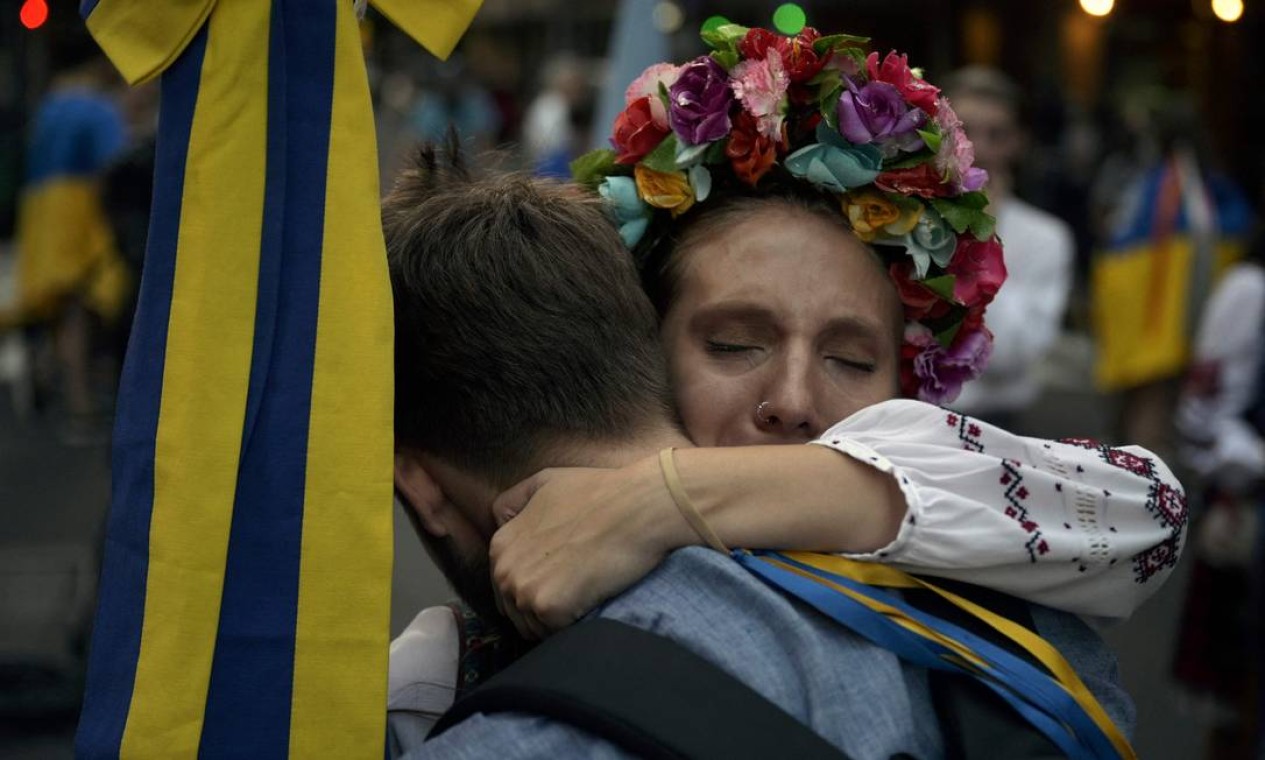 Membros da comunidade ucraniana se abraçam durante protesto do lado de fora da embaixada russa em Buenos Aires, Argentina Foto: JUAN MABROMATA / AFP