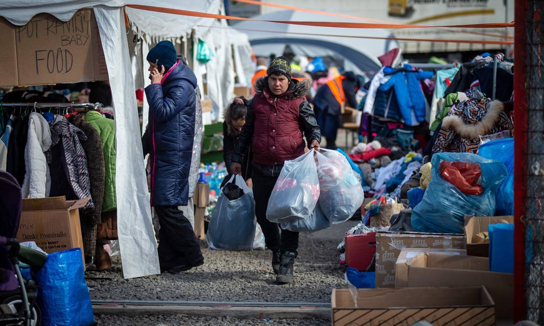 Roupas e alimentos são oferecidos a mulheres e crianças ucranianas que cruzam a fronteira eslovaca-ucraniana para deixar seu país em Vysne Nemecke, leste da Eslováquia Foto: PETER LAZAR / AFP Foto: PETER LAZAR / AFP