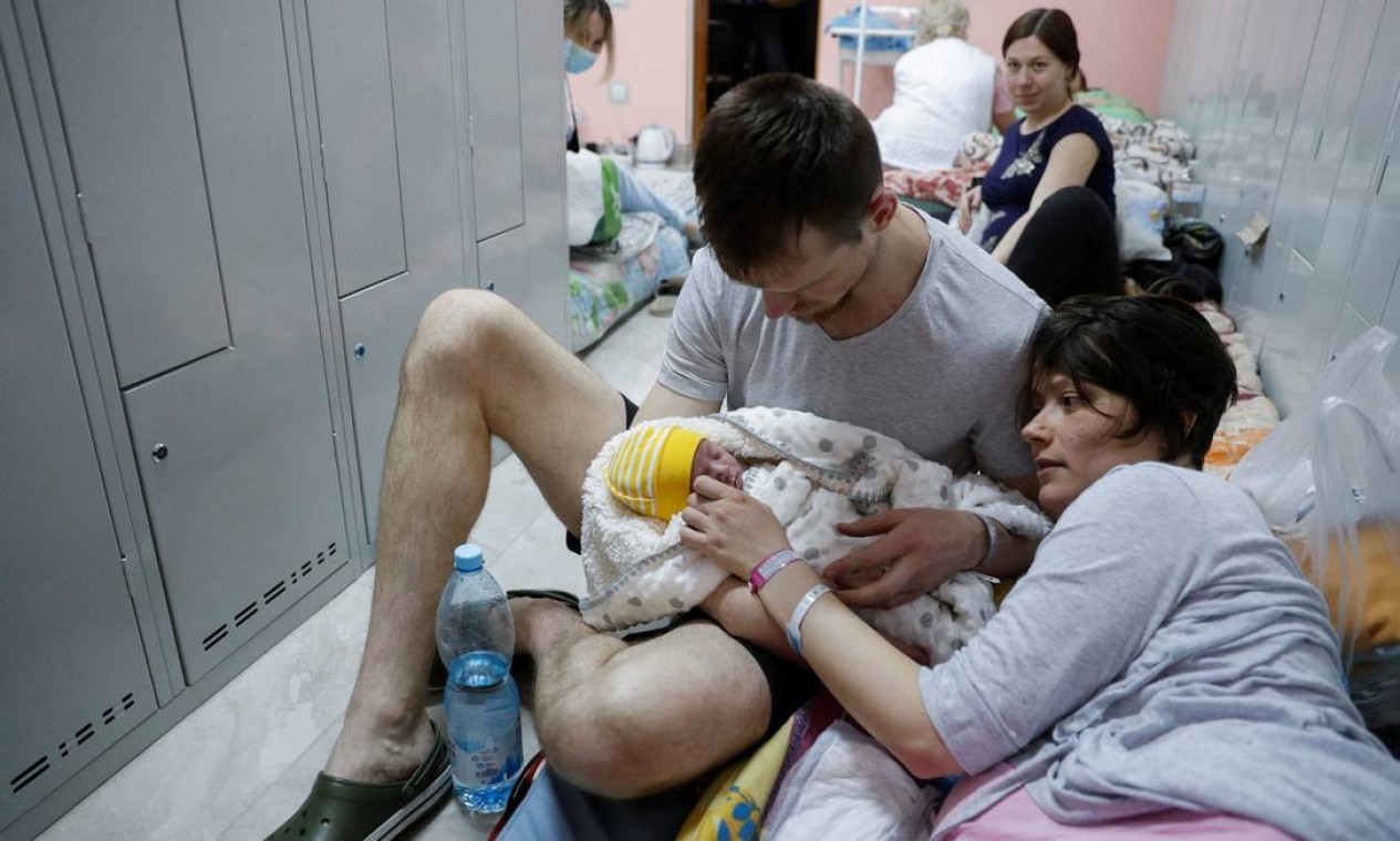 Casal com seu bebê recém-nascido se abriga no porão de um centro perinatal enquanto sons de sirene de ataque aéreo são ouvidos em meio à invasão russa da Ucrânia, em Kiev, Ucrânia Foto: VALENTYN OGIRENKO / REUTERS