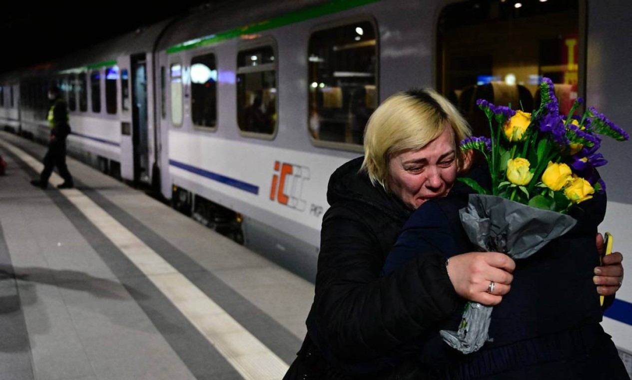 Mulher é consolada por um amigo depois de chegar de trem da fronteira com a Ucrânia na principal estação ferroviária de Berlim Foto: TOBIAS SCHWARZ / AFP