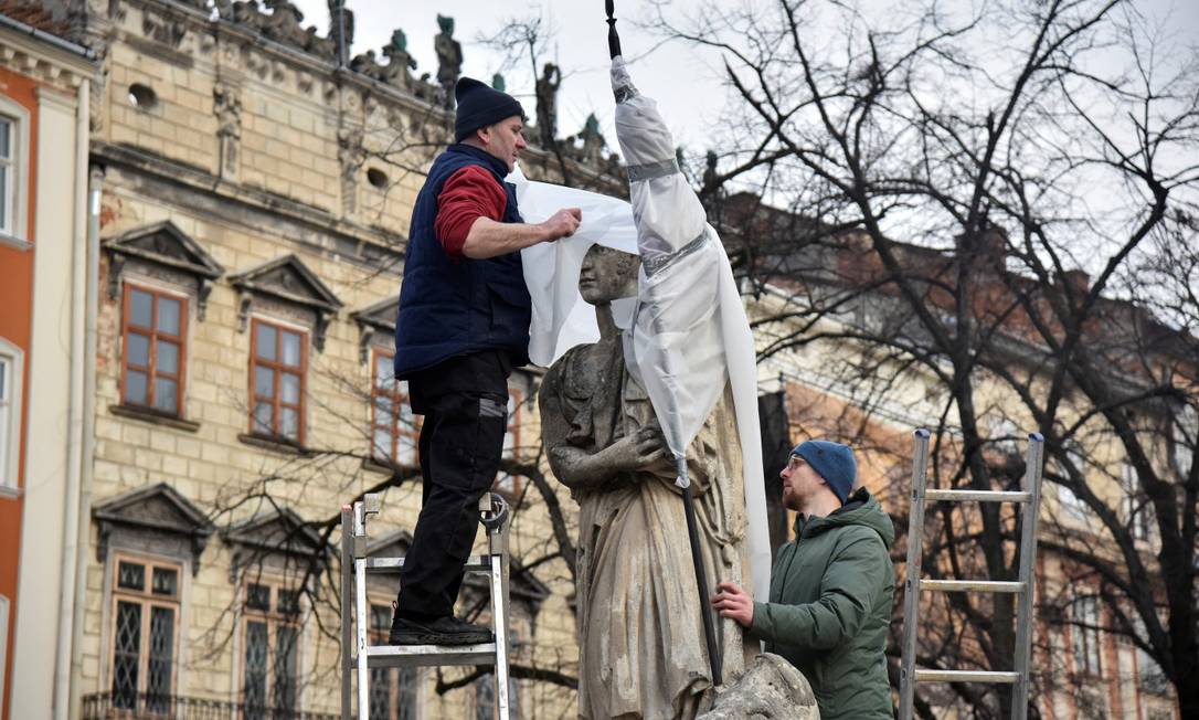 Trabalhadores envolvem estátua para protegê-la em caso de possível bombardeio, em meio à invasão russa da Ucrânia, em Lviv, Ucrânia Foto: PAVLO PALAMARCHUK / REUTERS