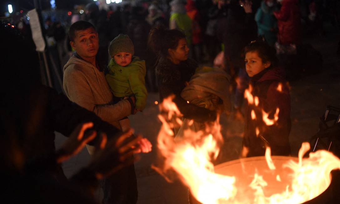 Refugiados se aquecem em torno de uma fogueira do lado de fora da estação de trem de Lviv, oeste da Ucrânia Foto: DANIEL LEAL / AFP