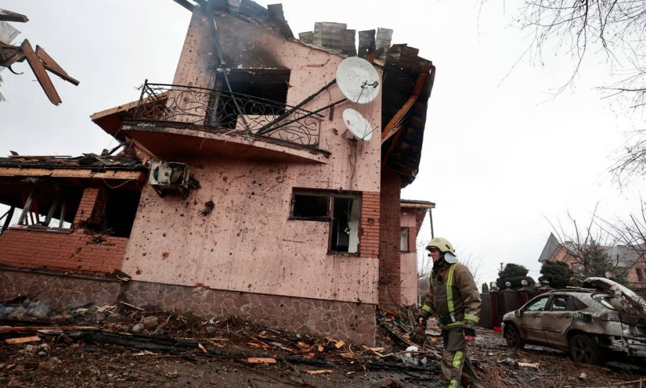 Bombeiro caminha perto de casa danificada por bombardeios na vila de Hatne, enquanto a invasão russa da Ucrânia continua, na região de Kiev Foto: SERHII NUZHNENKO / REUTERS