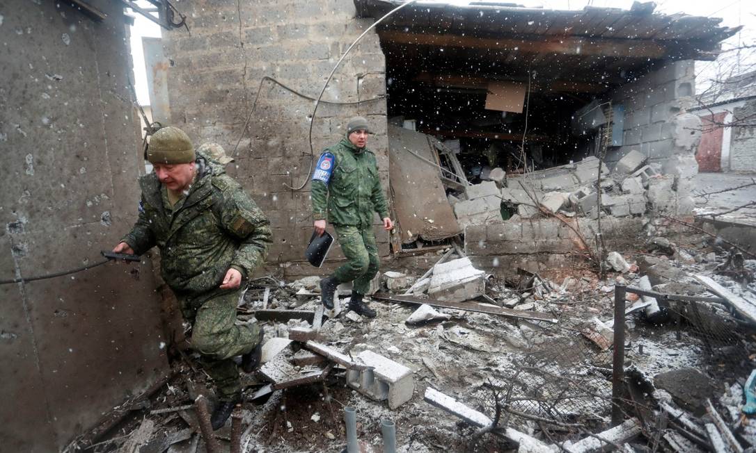 Oficiais do Centro Conjunto de Controle e Coordenação inspecionam casa danificada após bombardeio na cidade controlada pelos separatistas de Donetsk, Ucrânia Foto: ALEXANDER ERMOCHENKO / REUTERS