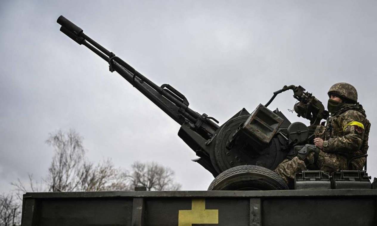 Soldado ucraniano mantém posição em uma arma antiaérea na linha de frente, a nordeste de Kiev Foto: ARIS MESSINIS / AFP