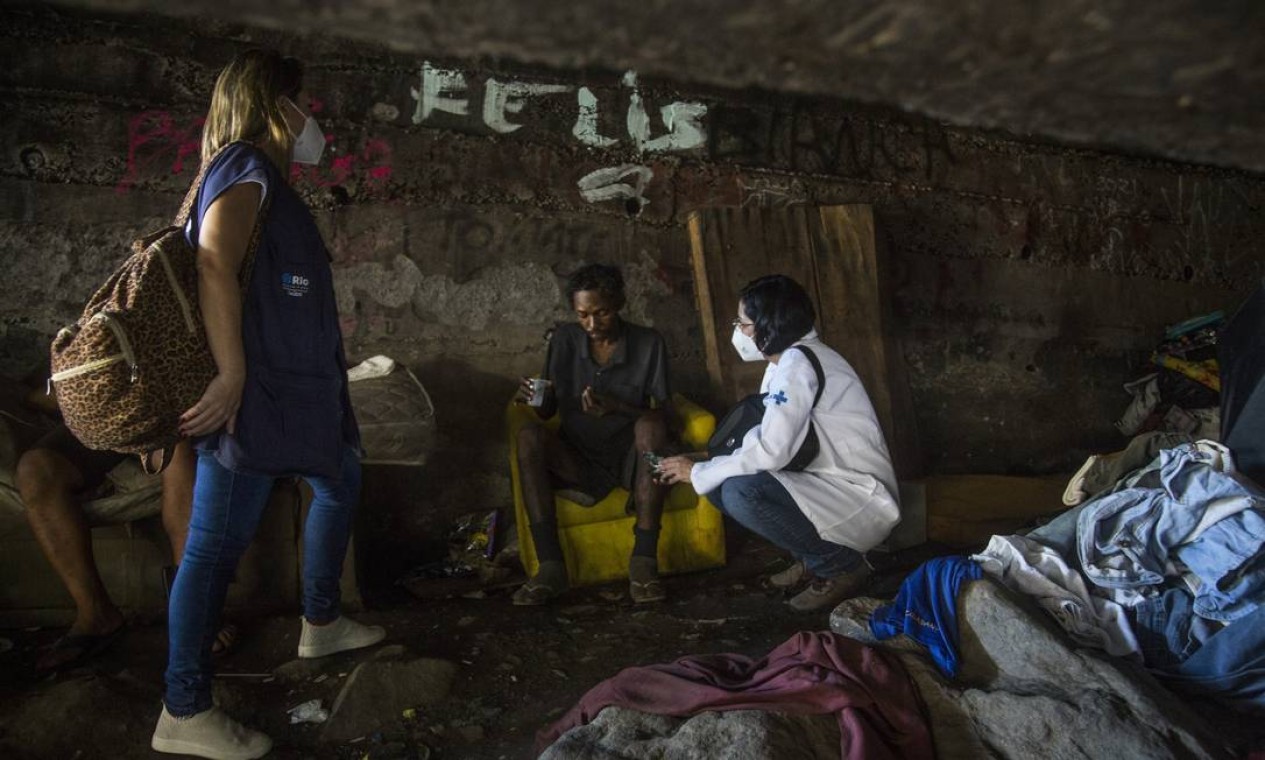 Pessoas que moram num buraco, na Fazenda Botafogo, recebem atendimento médico de uma equipe da Secretaria municipal de Saúde Foto: Guito Moreto / Agência O Globo