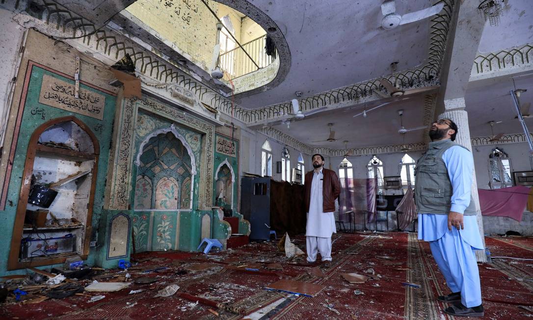 Pessoas em meio aos danos o salão de oração após uma explosão de bomba dentro de uma mesquita em Peshawar, no Paquistão Foto: FAYAZ AZIZ / REUTERS