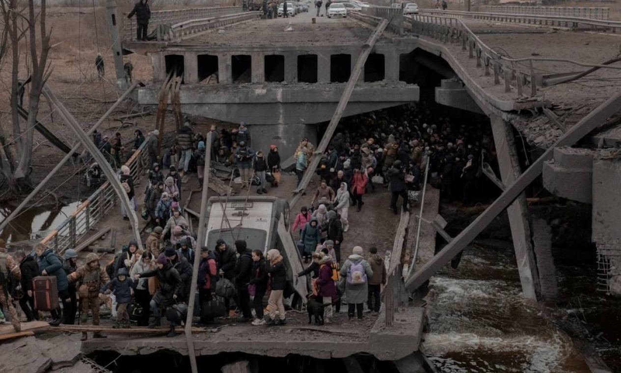 Pessoas atravessam uma ponte destruída enquanto tentam deixar a cidade de Irpin, na região de Kiev Foto: JEDRZEJ NOWICKI/AGENCJA WYBORCZA / Agencja Wyborcza.pl via REUTERS
