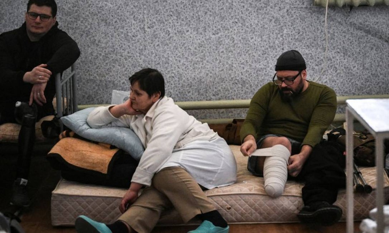 Soldado ferido enrola seu curativo em um hospital militar na cidade de Irpin Foto: ARIS MESSINIS / AFP