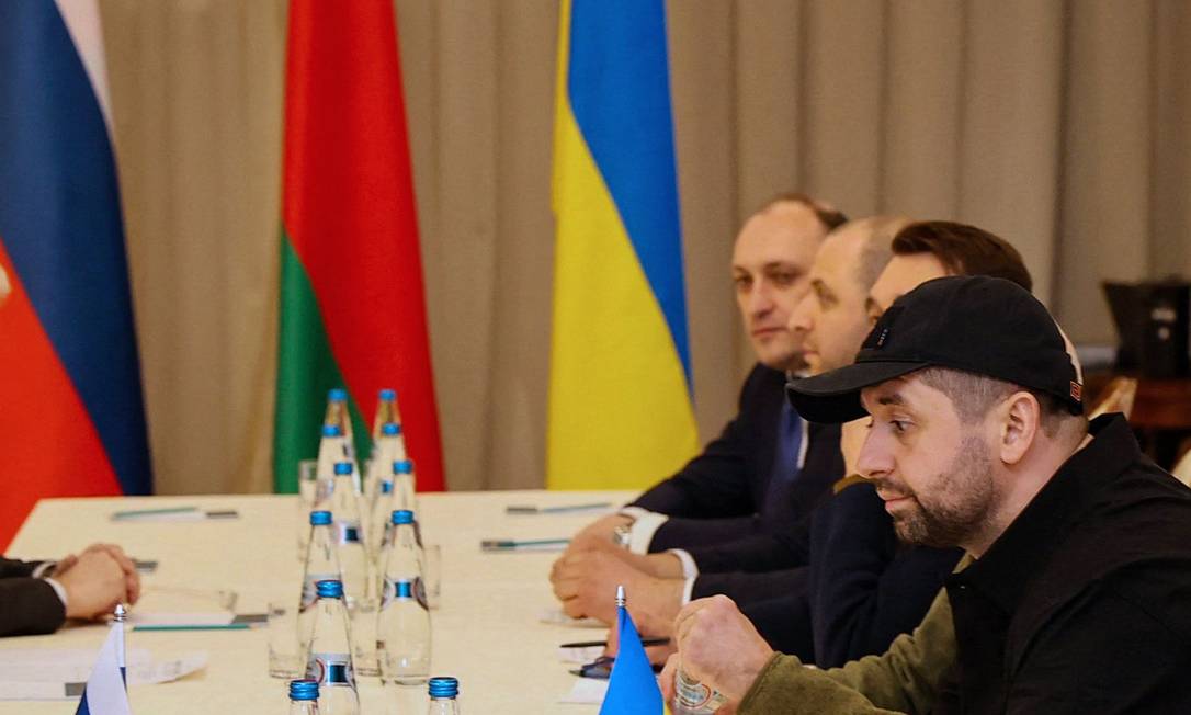 Reunião de representantes russos e ucranianos em Gomel: Denis Kireyev aparece ao fundo, à direita, ao lado da bandeira da Ucrânia Foto: SERGEI KHOLODILIN / AFP/28-02-2022
