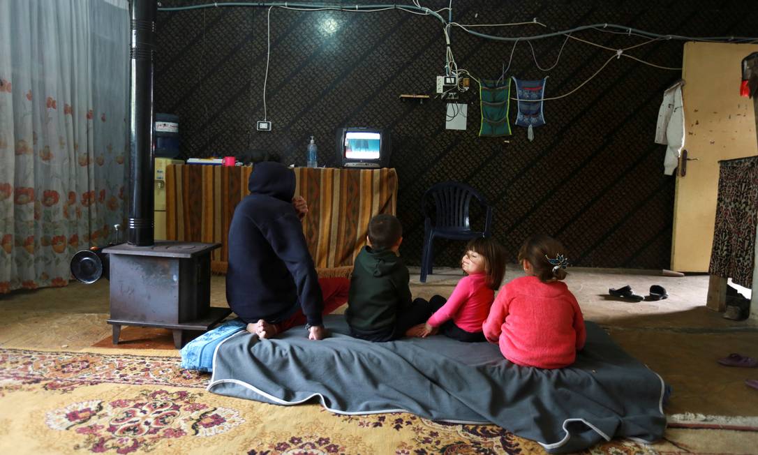 Refugiados da guerra civil na Síria assistem TV em campo de Aabra, no Líbano; no total, sírios que fugiram do conflito somam 6,7 milhões Foto: AZIZ TAHER / REUTERS/1-3-2021