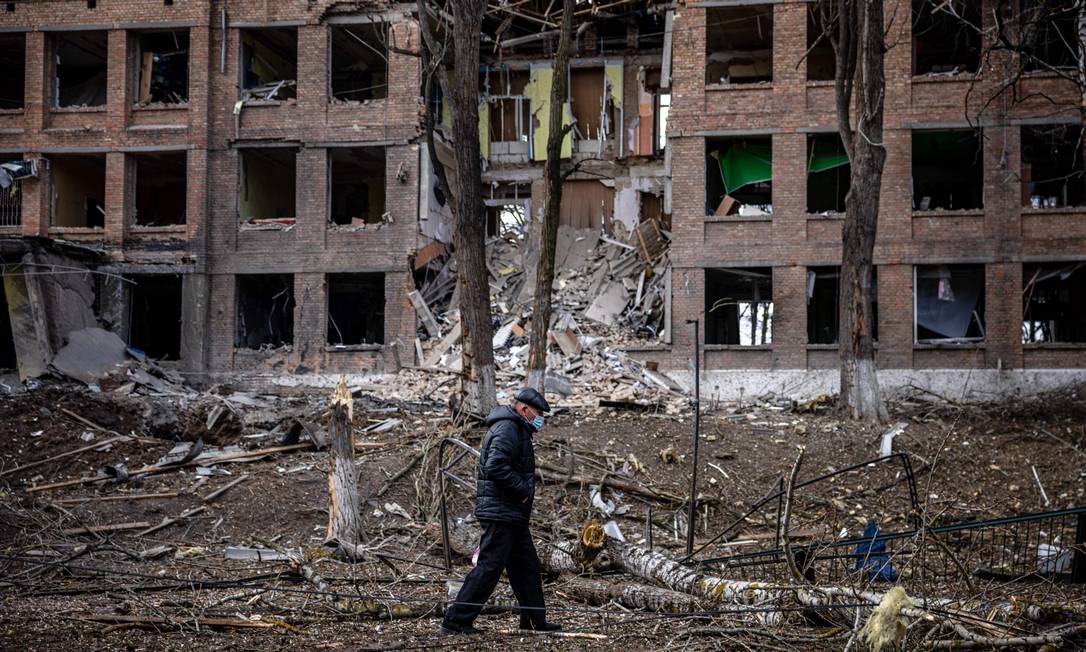 Homem caminha em frente a prédio destruído por míssil russo em Vasylkiv, cidade próxima a Kiev, capital da Ucrânia Foto: DIMITAR DILKOFF / AFP