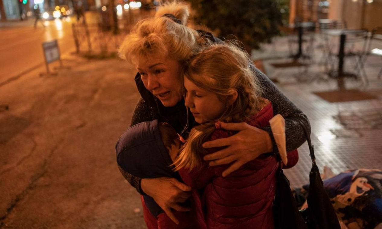Refugiado ucraniano da cidade portuária de Odessa, no Mar Negro, abraça duas crianças quando chegam a Atenas de ônibus. Mais de 1,5 milhão de refugiados fugiram da Ucrânia desde a invasão russa Foto: ANGELOS TZORTZINIS / AFP