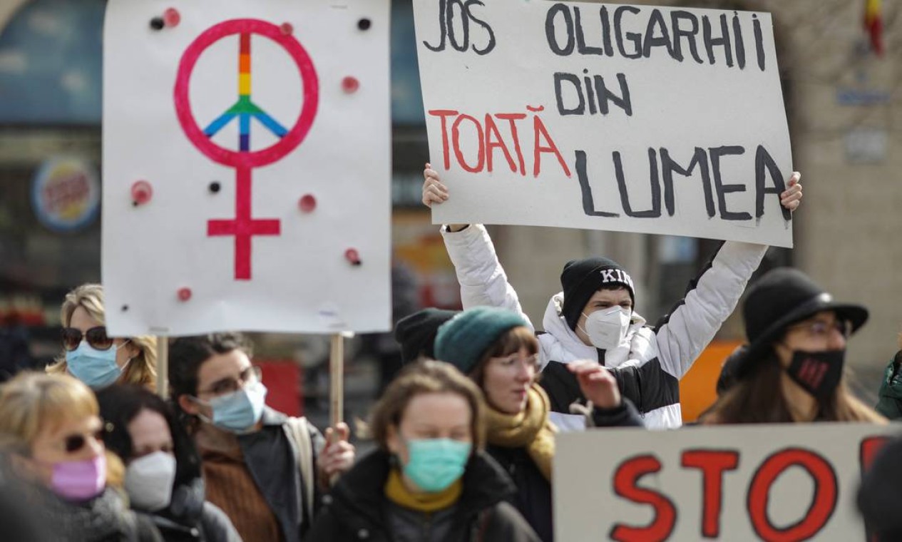 Homem segura um cartaz que diz "Abaixo os oligarcas do mundo!", durante um protesto pedindo solidariedade mundial às mulheres em Bucareste, Romênia Foto: INQUAM PHOTOS/Octav Ganea / via REUTERS