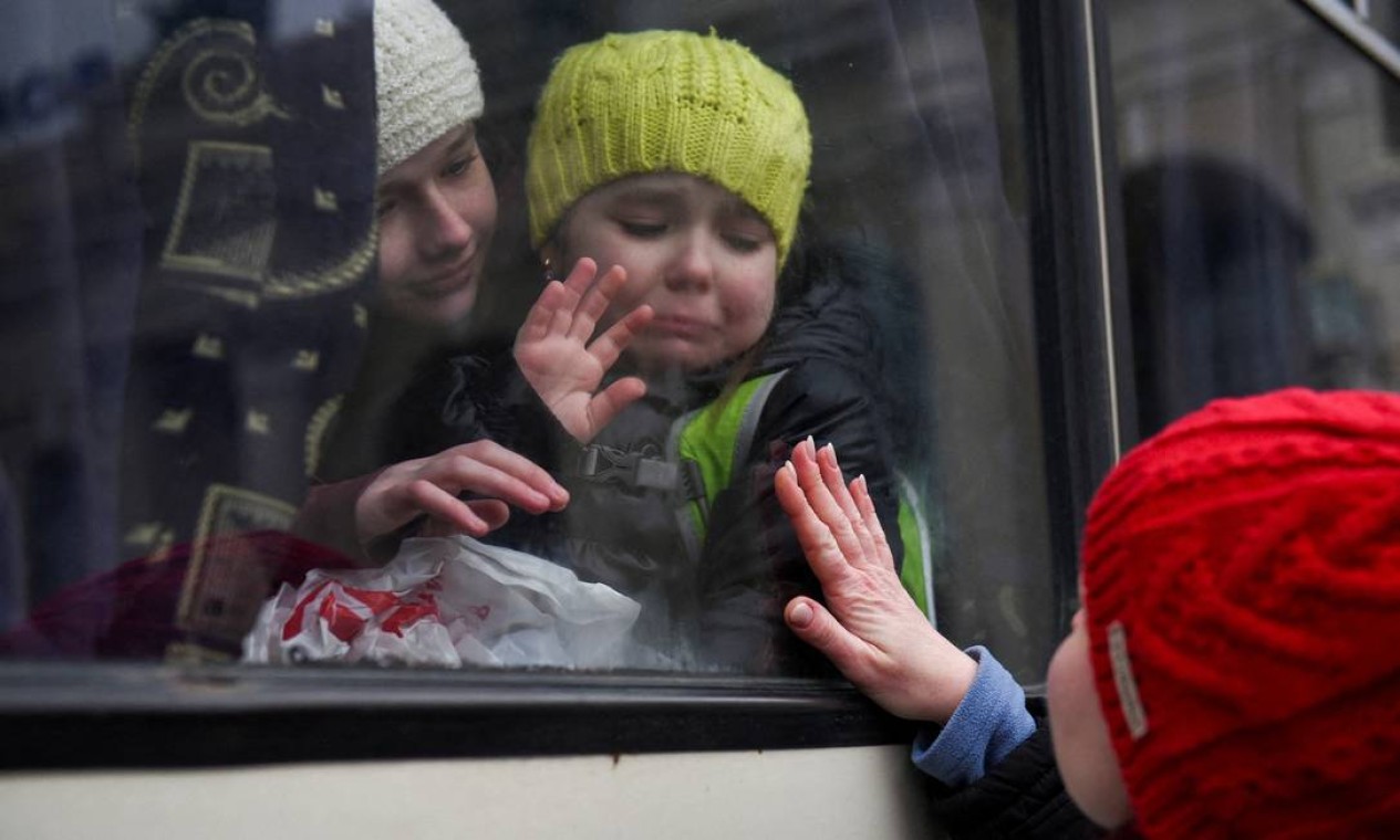 Alexandra, 12, segura sua irmã Esyea, 6, que chora enquanto acena para sua mãe Irina, fogem de ônibus da Ucrânia Foto: ALEXANDROS AVRAMIDIS / REUTERS