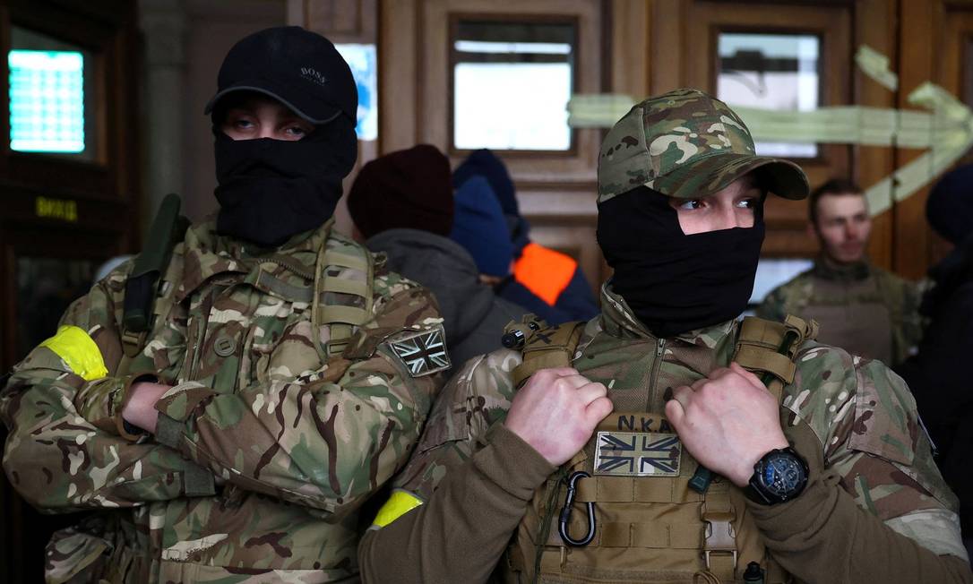 Combatentes estrangeiros do Reino Unido posam para uma foto antes de sua partida em direção à linha de frente no leste da Ucrânia após a invasão russa, na principal estação de trem em Lviv, Ucrânia Foto: Kai Pfaffenbach / Reuters