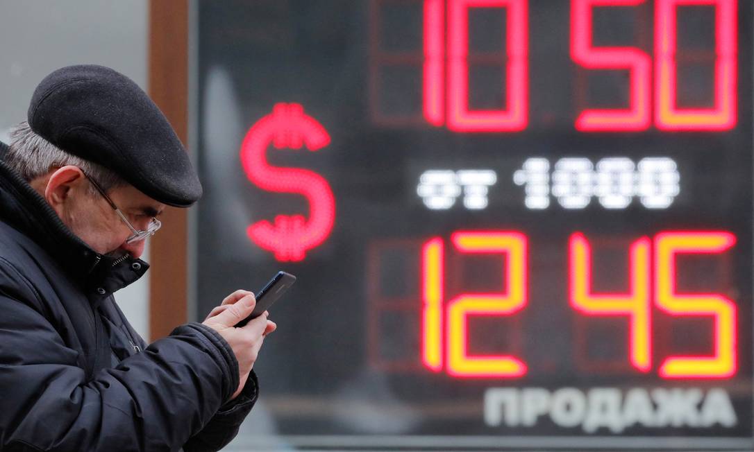 Homem passa em frente a um quadro mostrando as taxas de câmbio do dólar americano em relação ao rublo russo em São Petersburgo, na Rússia Foto: Anton Vaganov / Reuters / 28-2-2022
