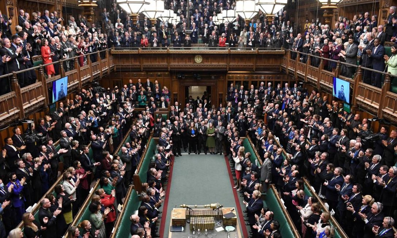 Parlamentares britânicos aplaudemde pé o presidente da Ucrânia, Volodymyr Zelensky, depois de conferência realizada por vídeo ao vivo na Câmara dos Comuns, em Londres Foto: JESSICA TAYLOR / AFP