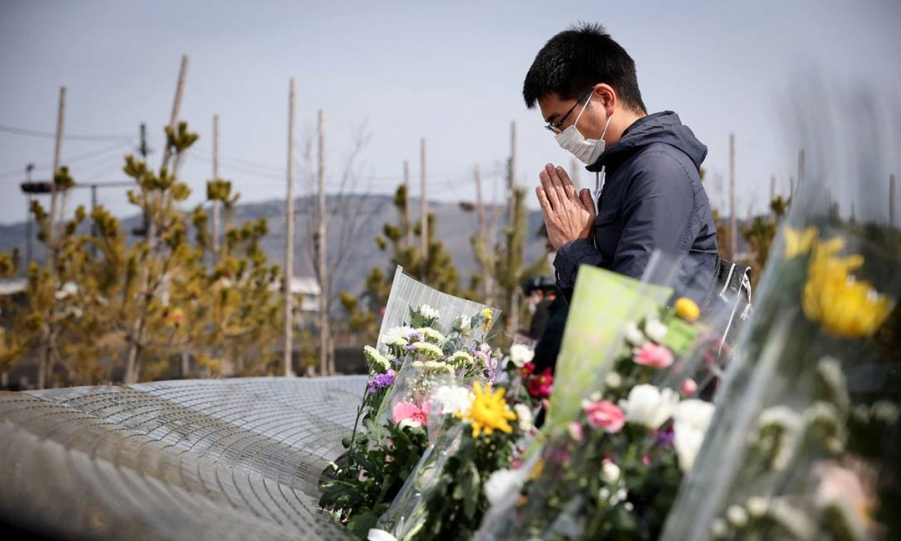 Homem reza em frente a um monumento memorial para o terremoto e tsunami do Grande Leste do Japão de 2011, em Ishinomaki, prefeitura de Miyagi. O desastre deixou mais de 18.000 pessoas mortas ou desaparecidas Foto: STR / AFP
