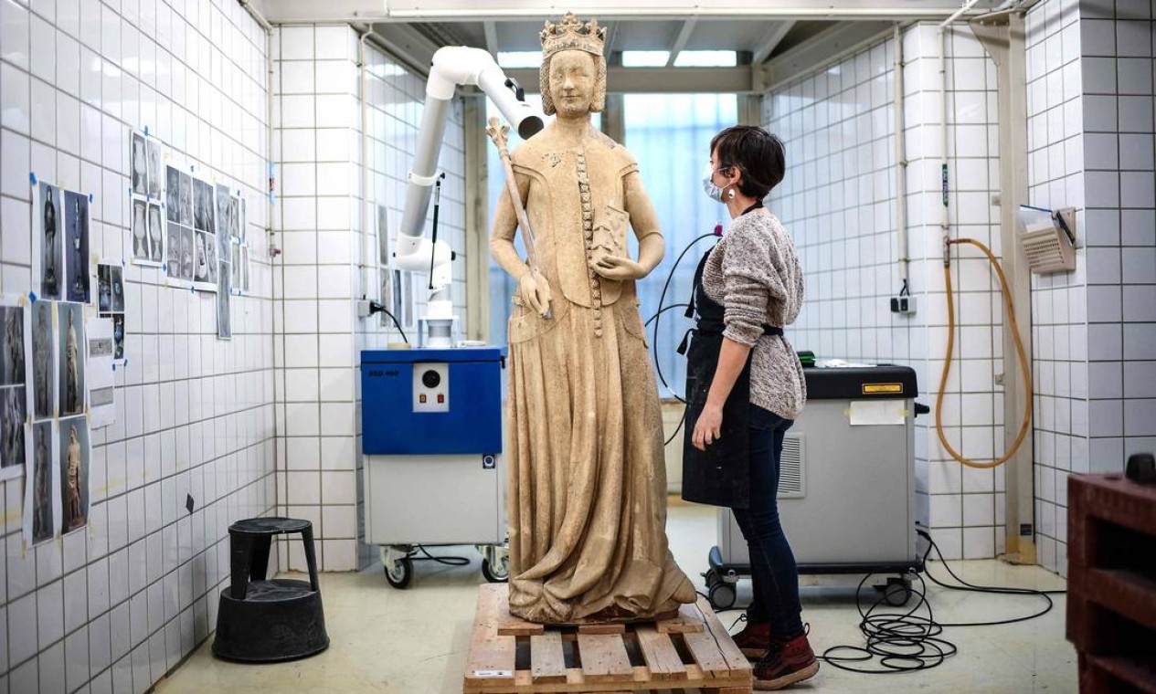 Restaurador de arte inspeciona estátua medieval de Jeanne de Bourbon, no Centro de Pesquisa e Restauração, do Palácio du Louvre, em Paris, França Foto: CHRISTOPHE ARCHAMBAULT / AFP