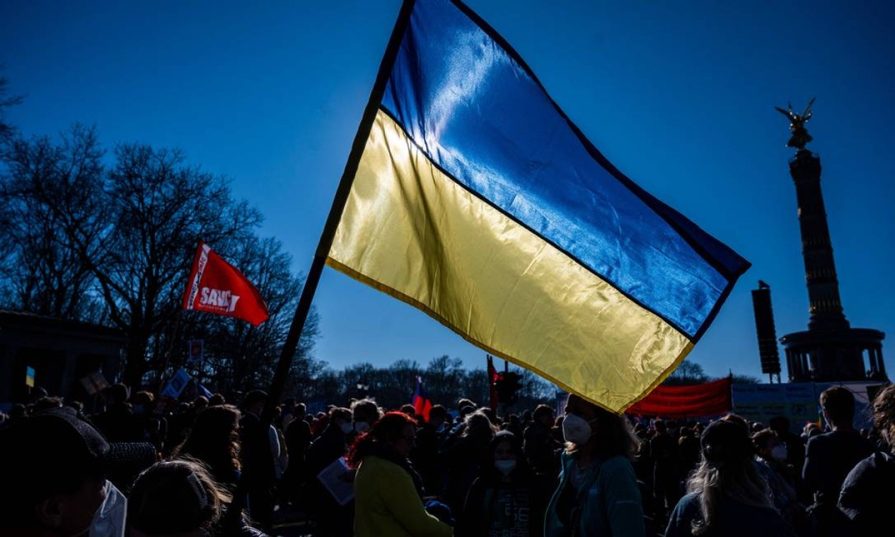Manifestantes agitam bandeira ucraniana durante protesto em Berlim Foto: JOHN MACDOUGALL / AFP