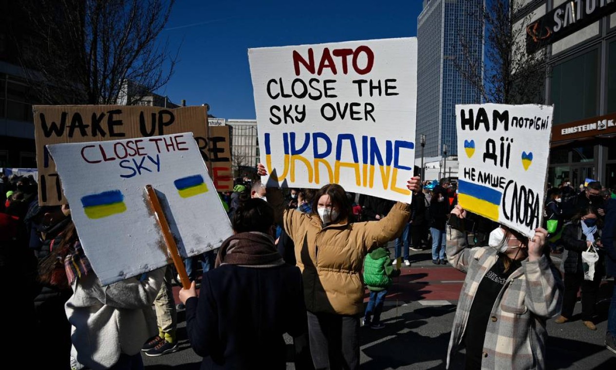 "OTan, feche o céu sobre a Ucrânia", diz cartaz dos manifestantes em Berlim Foto: JOHN MACDOUGALL / AFP