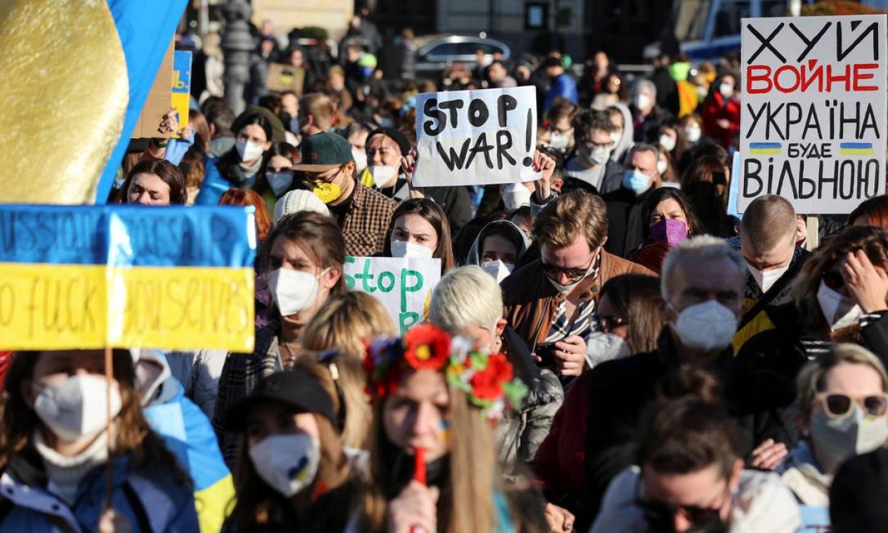 Manifestantes carregam cartazes durante uma manifestação anti-guerra. "Pare a guerra", "Paz e Solidariedade para o Povo na Ucrânia", dizem cartazes escritos em inglês e russo Foto: CHRISTIAN MANG / REUTERS